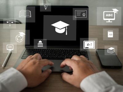 Person typing on a laptop displaying a graduation cap icon, surrounded by digital education symbols representing online learning and skill development.