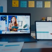 Student attending an online class on a laptop and tablet at home at night.