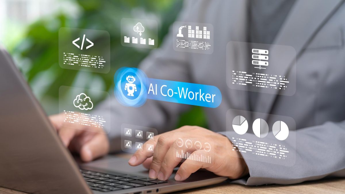 Professional using a laptop with a digital AI co-worker interface displayed on screen, featuring data analytics, cloud storage, coding, and workflow automation icons representing AI-powered workplace productivity and collaboration.